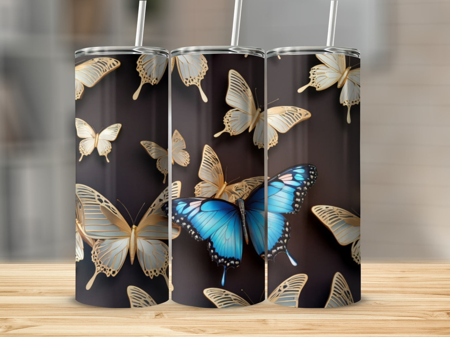Three tumblers with a dark background and gold and blue butterfly designs.