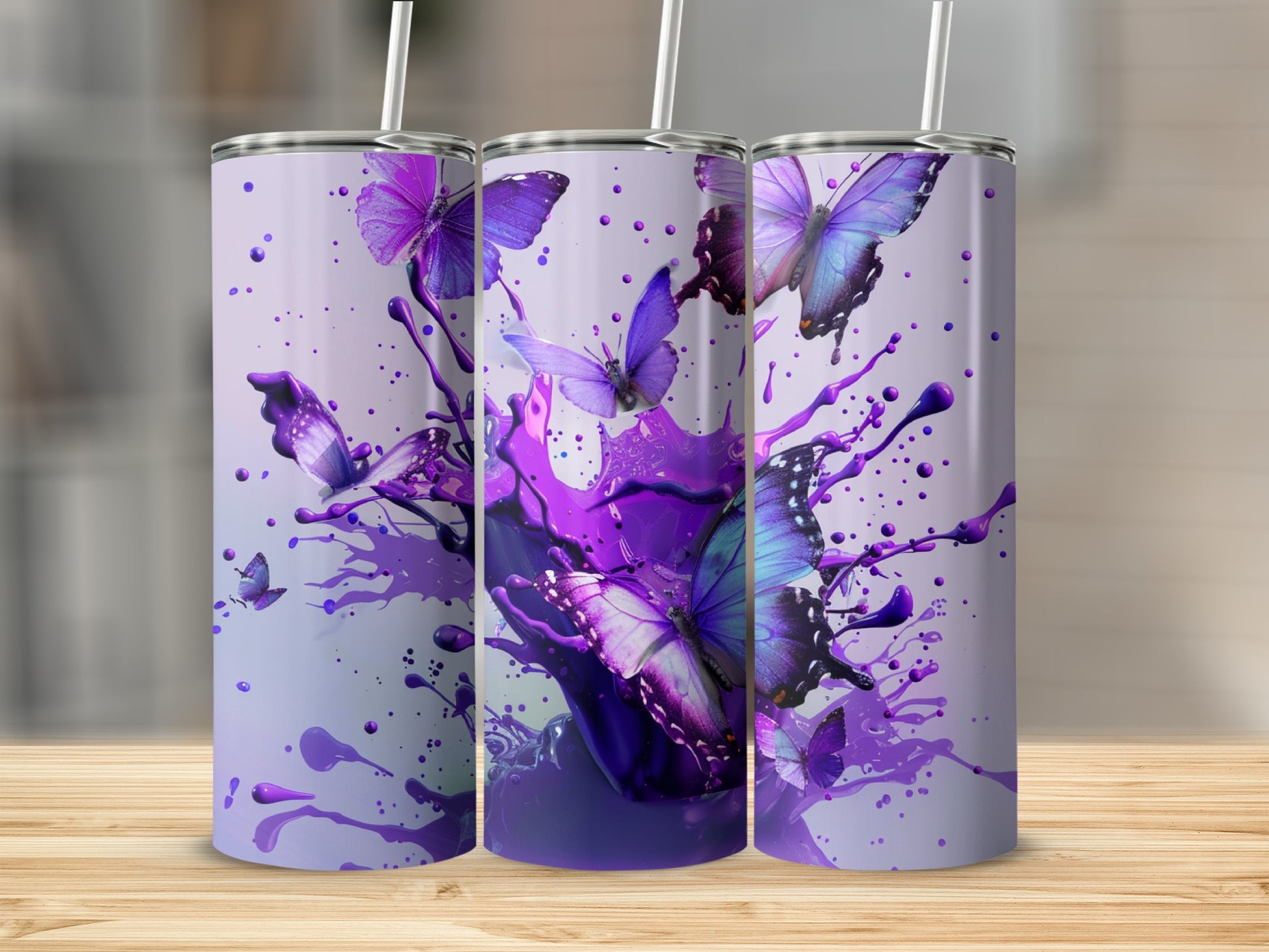Purple butterflies emerge from purple paint splashes on three tumblers.