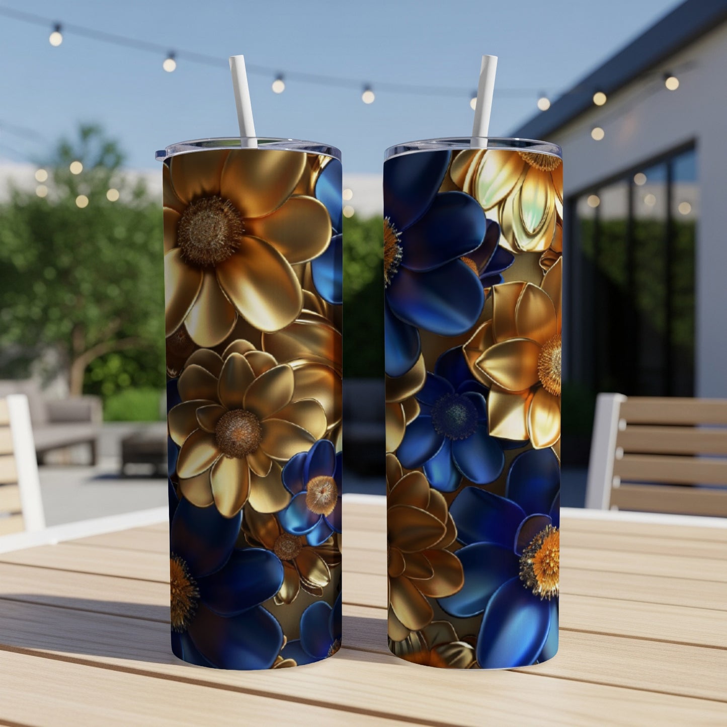 Two tumblers with golden and blue floral designs on a wooden table outdoors.