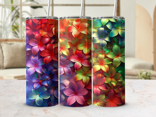 Three colorful tumblers with vibrant floral patterns sit on a marbled surface.