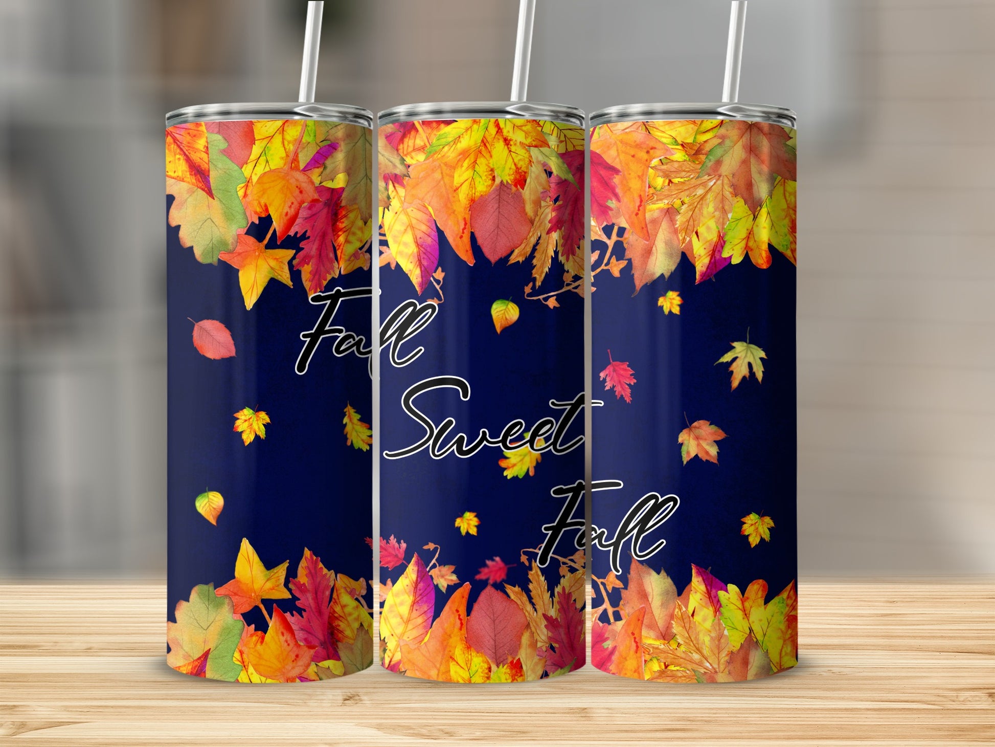Three tumblers with a dark blue background and colorful falling autumn leaves design.