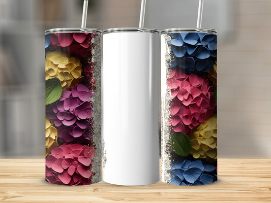 Three tumblers with floral patterns and glitter trim on a wooden surface.