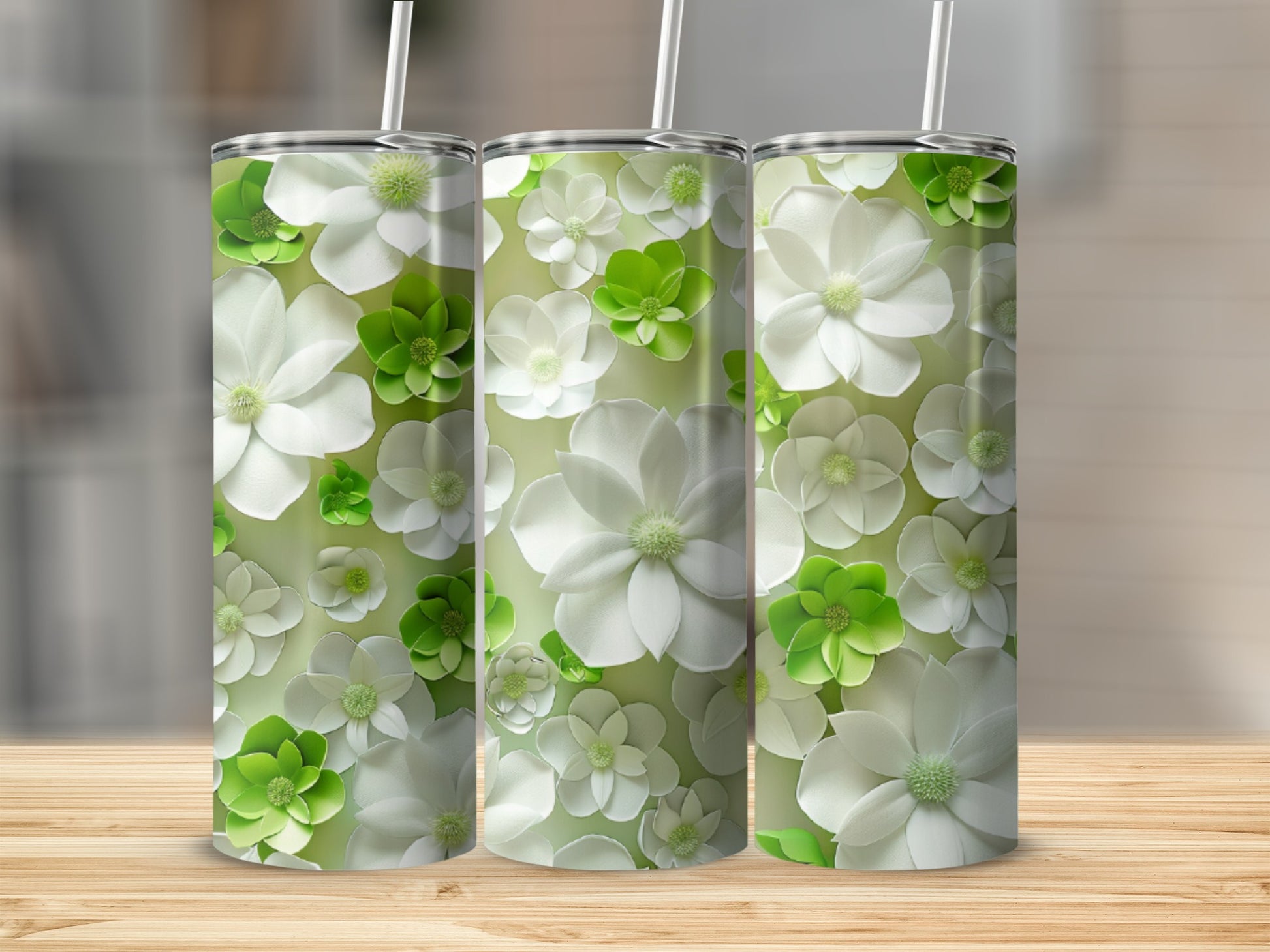 Three tumblers with a repeating pattern of white and green flowers on a light green background.