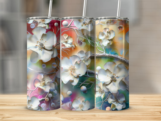 Three tumblers with white floral and abstract colorful designs on a wooden surface.