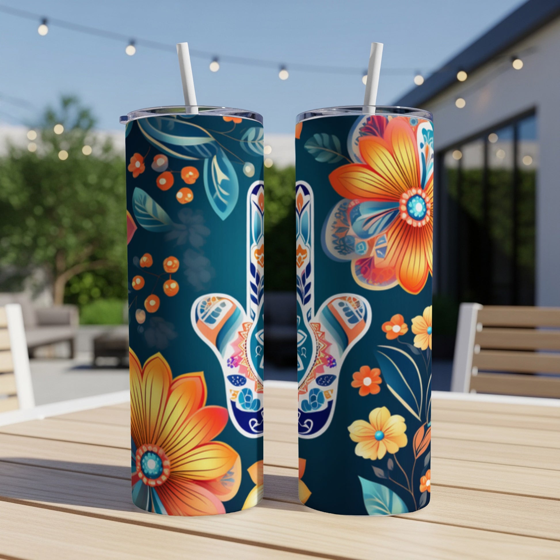 Two tall tumblers with floral and mandala patterns sit on a wooden table.